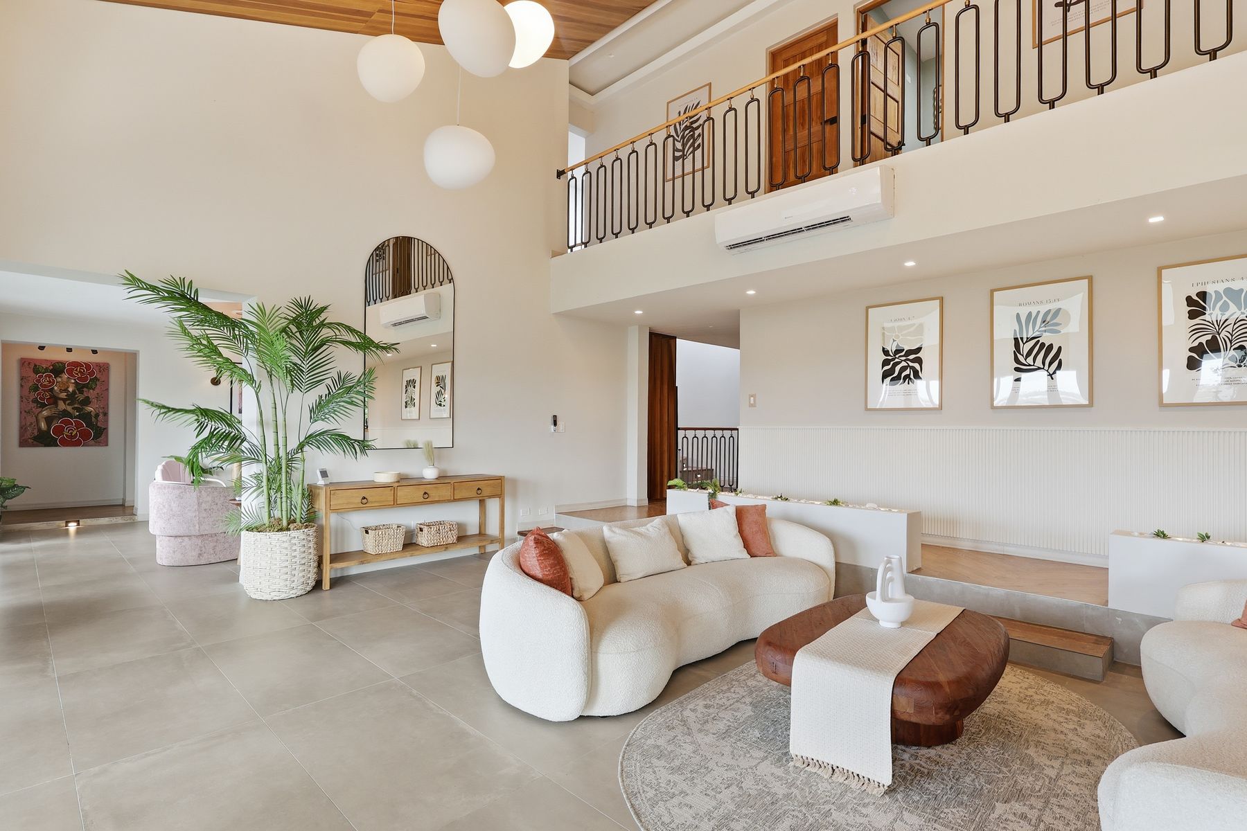Open-plan living room with double-height gallery wall and balcony — Bou Photography, Puerto Rico
